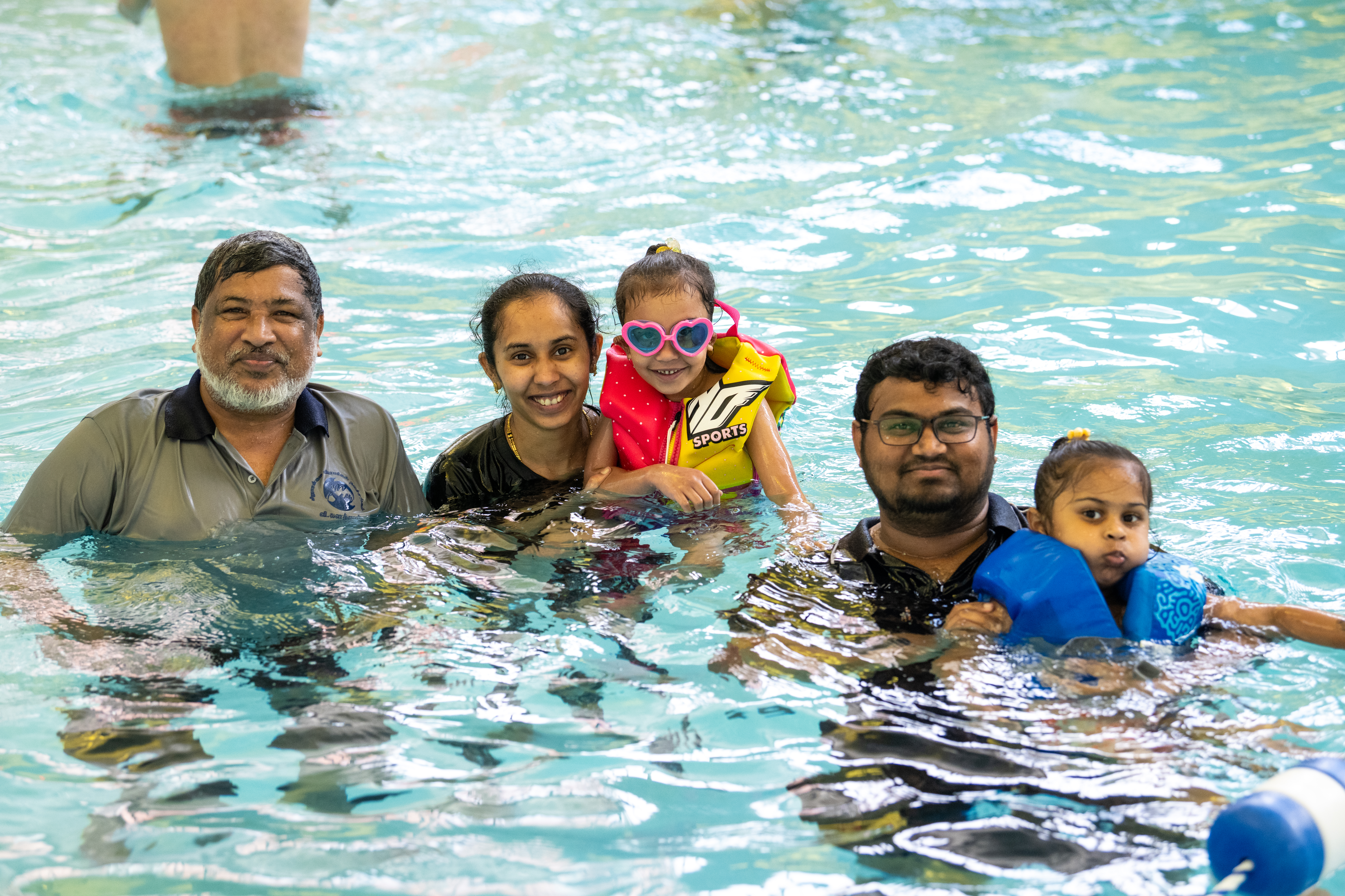 Family of five in the pool smiling