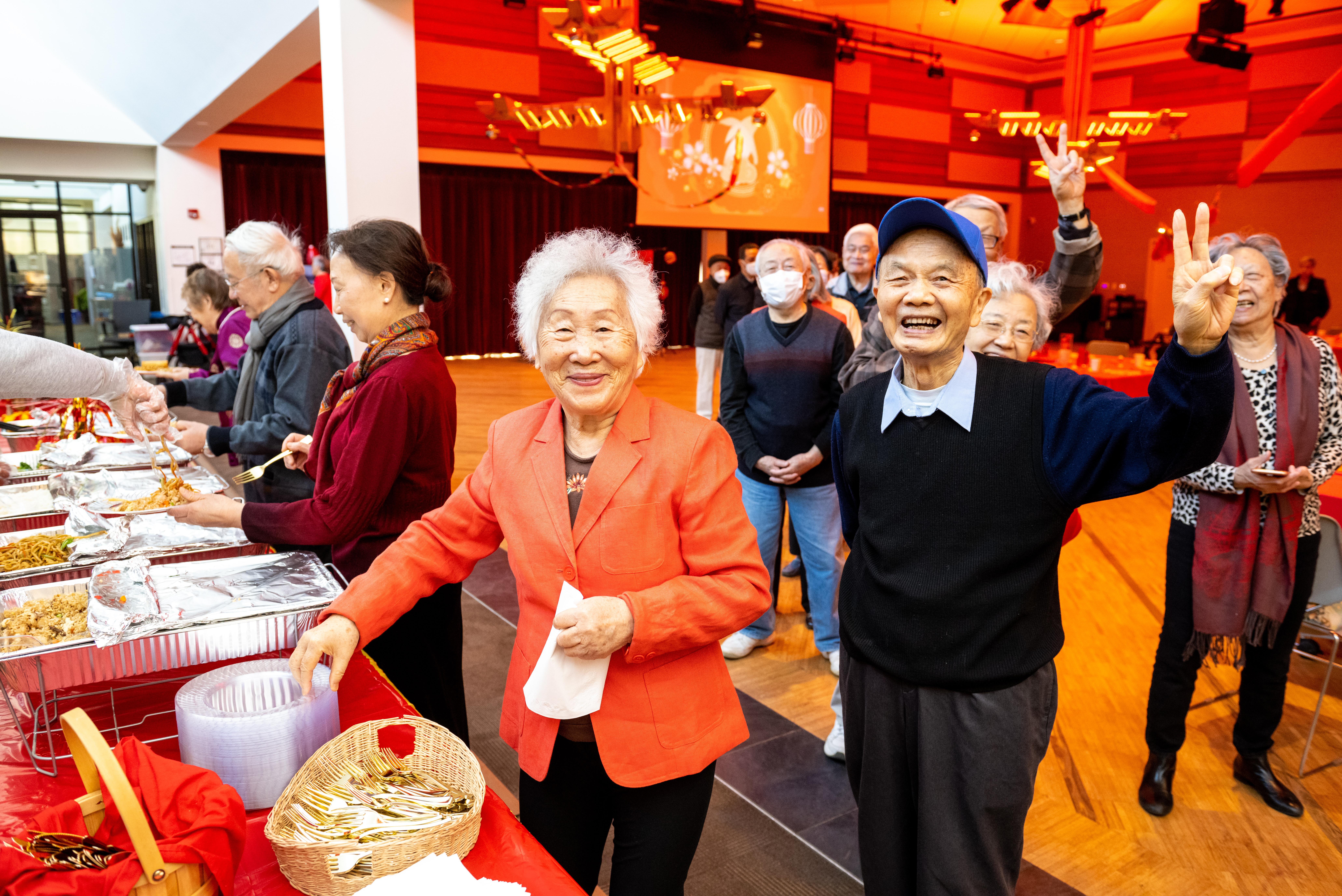 Community members smiling and serving food during the Lunar New Year celebration at Reston Community Center.
